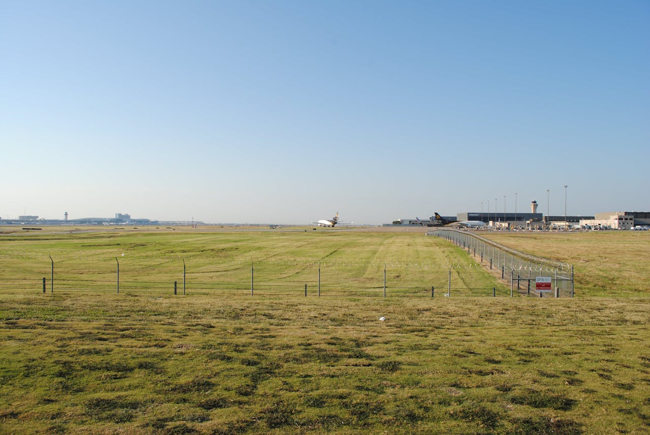 A commercial airplane on a runway at Grapevine airport, surrounded by grass fields.