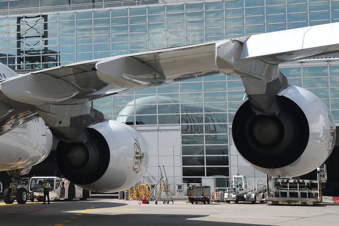 Detailed view of airplane engines at Frankfurt Airport terminal on a sunny day, showcasing modern aviation technology.